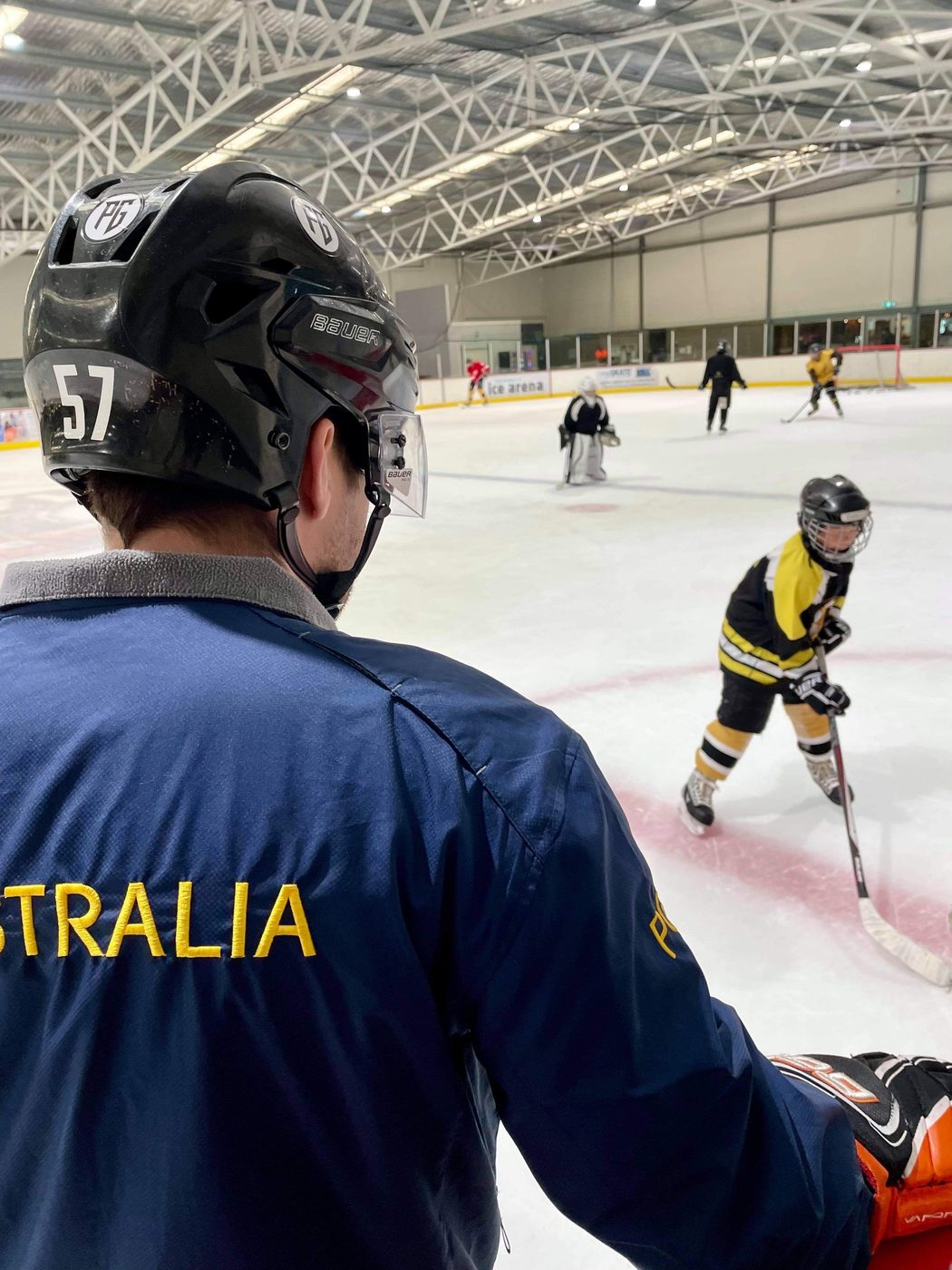 Paul Graham in his Australia coaching jacket watching a junior player train at Cockburn Ice Arena